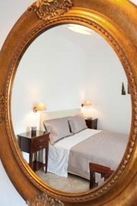 een slaapkamer met een bed en een tafel in een spiegel bij Tsakanos Apartments in Adamas