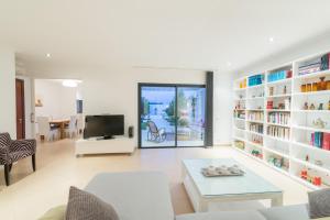 een woonkamer met witte planken en een tv bij Ca Na Molinera in Sant Joan