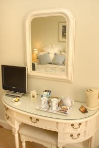 a white table with a television and a mirror at Courtland in Stratford-upon-Avon