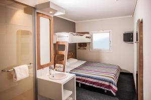 SUN1 PORT ELIZABETH في بورت اليزابيث: غرفة صغيرة مع سرير بطابقين ومغسلة
