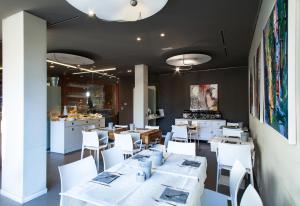 ein Restaurant mit weißen Tischen und weißen Stühlen in der Unterkunft Spluga Sosta & Hotel in Dubino