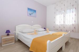 a bedroom with a bed with two stuffed animals on it at Apartments & Rooms Seaside in Kaštela