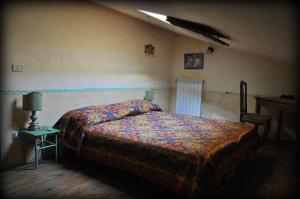 a bedroom with a bed and a table with a lamp at Podere di Maggio - Casa della Nonna in Santa Fiora