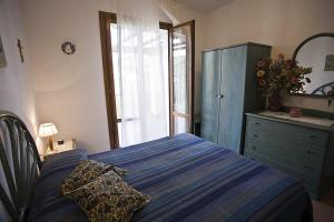 a bedroom with a bed and a dresser and a window at Villetta Olivo 5 Bagnaia in Bagnaia