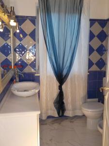 a bathroom with a toilet and a blue shower curtain at Appartement Villa Angelina in Grimaud