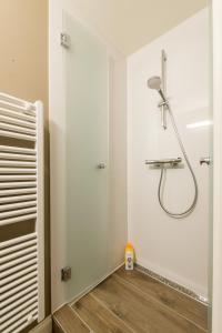 a bathroom with a shower with a shower head on the wall at Verbrand Nieuwland in Bruges +15 photos