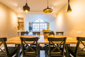 a dining room with a wooden table and chairs at Verbrand Nieuwland in Bruges