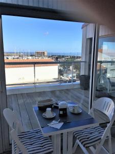 a table and chairs on a balcony with a view at Hotel Bord A Bord in Noirmoutier-en-l'lle