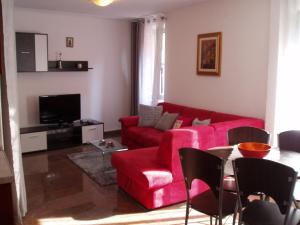 a living room with a red couch and a table at Apartment Oaza in Rovinj