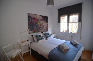 a bedroom with a bed and a chair in it at RentBCN Park Guell in Barcelona