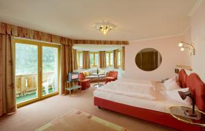 ein Schlafzimmer mit einem Bett und ein Wohnzimmer in der Unterkunft Hotel Olympia in Pettneu am Arlberg
