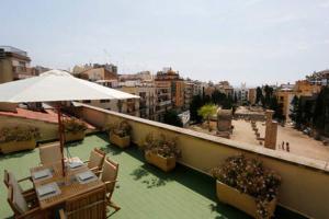 balkon ze stołami, krzesłami i parasolem w obiekcie ÁTICO DUPLEX CON VISTAS AL FORO ROMANO w mieście Tarragona