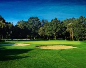 een golfbaan met een zandbunker op een groen bij Hotel Doge in Milano Marittima