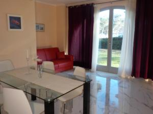 salon ze szklanym stołem i czerwoną kanapą w obiekcie Appartement Villa Angelina w mieście Grimaud
