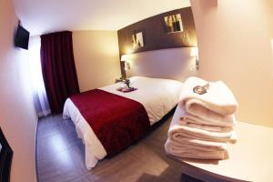 een hotelkamer met een bed met handdoeken erop bij Hotel Le Coudon in La Farlède