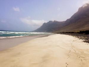 een strand met de oceaan en bergen op de achtergrond bij FCG24a in Famara