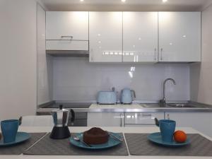 a kitchen with white cabinets and two plates of cake at playa honda luxury in Arona