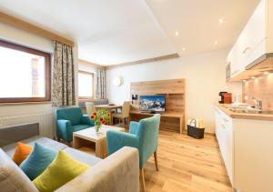 a living room with a couch and chairs and a kitchen at Family Apart Stubai in Fulpmes