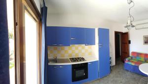 una cucina blu con lavandino e piano cottura di Villa Simius a Villasimius