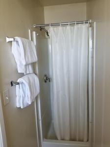 a bathroom with a shower with white towels at Lido Hotel in Huntington Park