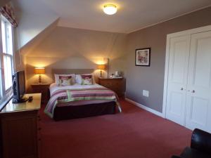 a bedroom with a bed and a dresser at Shaftesbury Hotel Dundee in Dundee