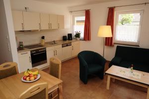 a kitchen and living room with a table with a bowl of fruit at Beim Kahnfährmann in Schlepzig