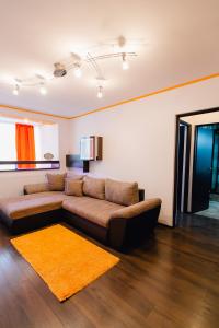 a living room with a brown couch and a yellow rug at Apartament Horatio in Galaţi