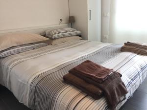 a bed with two towels on top of it at Residence La Nave in Senigallia