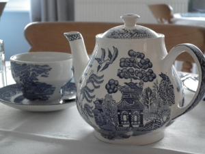 eine blau-weiße Teekanne und eine Tasse auf dem Tisch in der Unterkunft Dove House in Cheltenham