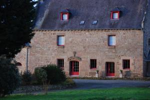 a large brick building with red doors and windows at Au Domaine de Rimou in Rimoux