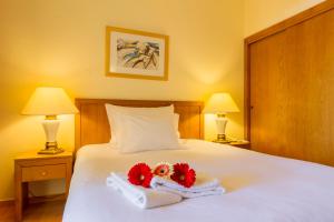 a bedroom with a bed with two towels and two lamps at Mirachoro Carvoeiro in Carvoeiro