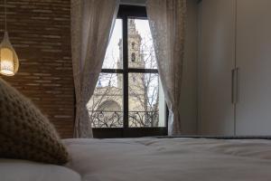 a bedroom with a bed and a window with a building at Apto con vistas a la catedral y aire acondicionado in Logroño