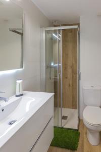 a white bathroom with a toilet and a glass shower at Apto con vistas a la catedral y aire acondicionado in Logroño