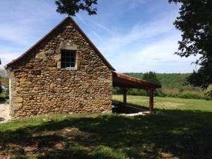 een stenen gebouw met een raam en een dak bij La Grange in Le Vigan
