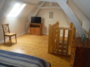 een slaapkamer met een bed en een televisie op zolder bij La Grange in Le Vigan