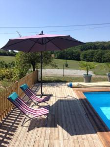 twee stoelen en een parasol naast een zwembad bij La Grange in Le Vigan +8 foto's