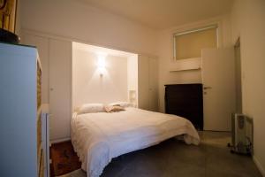 a bedroom with a bed with a cat laying on it at Modern apartment near the sea. in De Panne