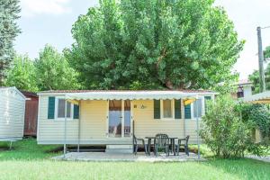 a small yellow house with a table and chairs at Camping Wien in Peschiera del Garda