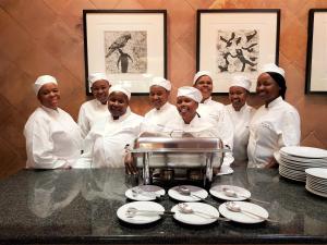 a group of chefs posing for a picture in a kitchen at African Roots Guest House - No Loadshedding in Polokwane