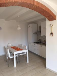 cocina y comedor con mesa blanca y sillas en La Chientina, en Soianella