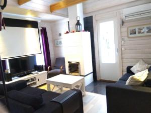 a living room with a couch and a flat screen tv at Villa Korpilo in Somero