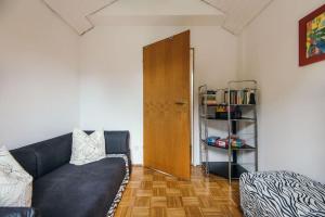 a living room with a black couch and a wooden door at Ferienwohnung am Seidlpark in Murnau am Staffelsee