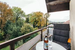 Una botella de cerveza sentada en una mesa en un balcón en Ferienwohnung am Seidlpark, en Murnau am Staffelsee