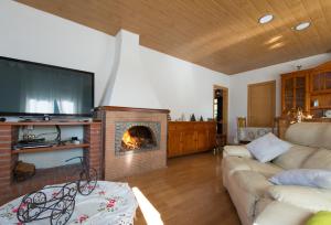 sala de estar con chimenea y sofá en Casa Can Vila Las Marquesas, en Sant Pere de Vilamajor