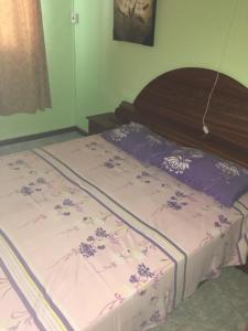 Schlafzimmer mit einem Bett mit lila und weißen Laken in der Unterkunft Lotus Apartments in Pereybere