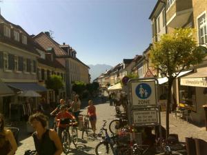 a group of people walking and riding bikes down a street at Ferienwohnung am Seidlpark in Murnau am Staffelsee +4 photos