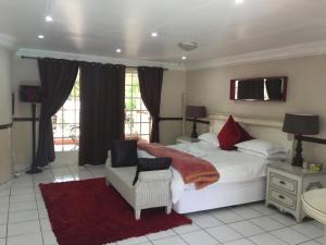 a bedroom with a large white bed and a chair at Summerview Guest Lodge in Johannesburg