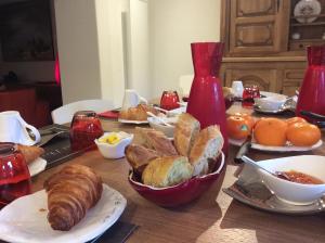 un tavolo con pane, cornetti e altri prodotti alimentari di Chambre d'hôtes Au Chant des Sorgues a Lagnes