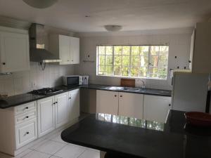 a kitchen with white cabinets and a window at Summerview Guest Lodge in Johannesburg