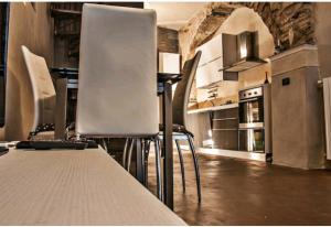 een keuken met witte stoelen en een tafel en apparatuur bij Ca' del Vescovo in Costarainera